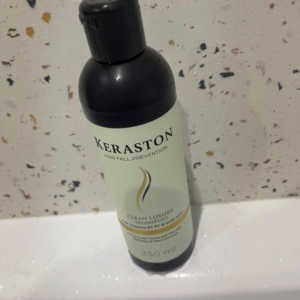 Flacone di shampoo Keraston da 250 ml appoggiato su un piano