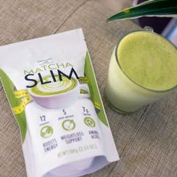 Busta bianca e verde di Matcha Slim da 100 g accanto a un bicchiere di bevanda verde