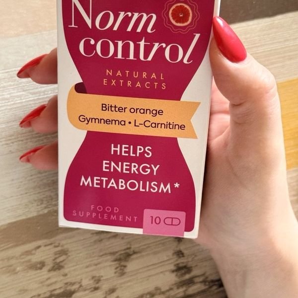 Scatola bianca e fucsia di Norm Control tenuta in mano